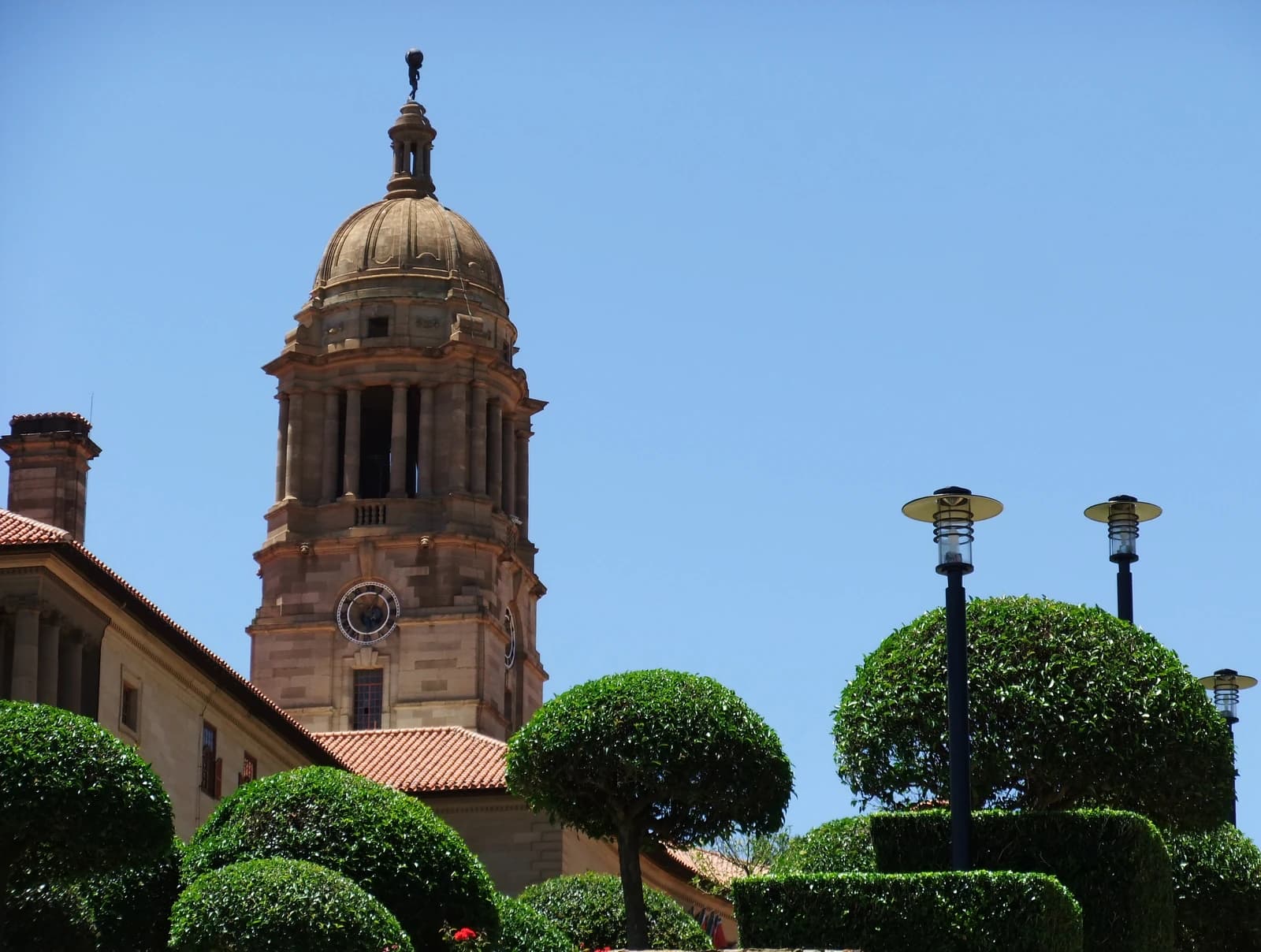The clock tower of the Union Buildings in Pretoria, South Africa, against a blue sky.