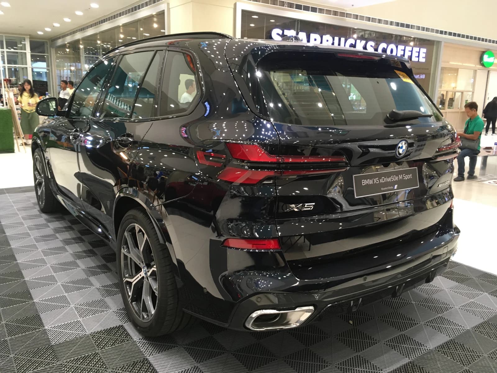 Black BMW X5 xDrive50e M Sport plug-in hybrid electric vehicle, rear view.