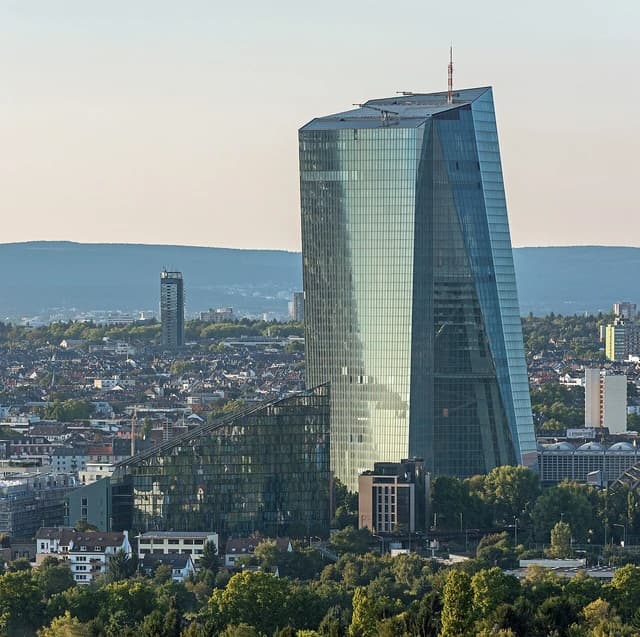 Aerial view of the European Central Bank headquarters building against a cityscape.