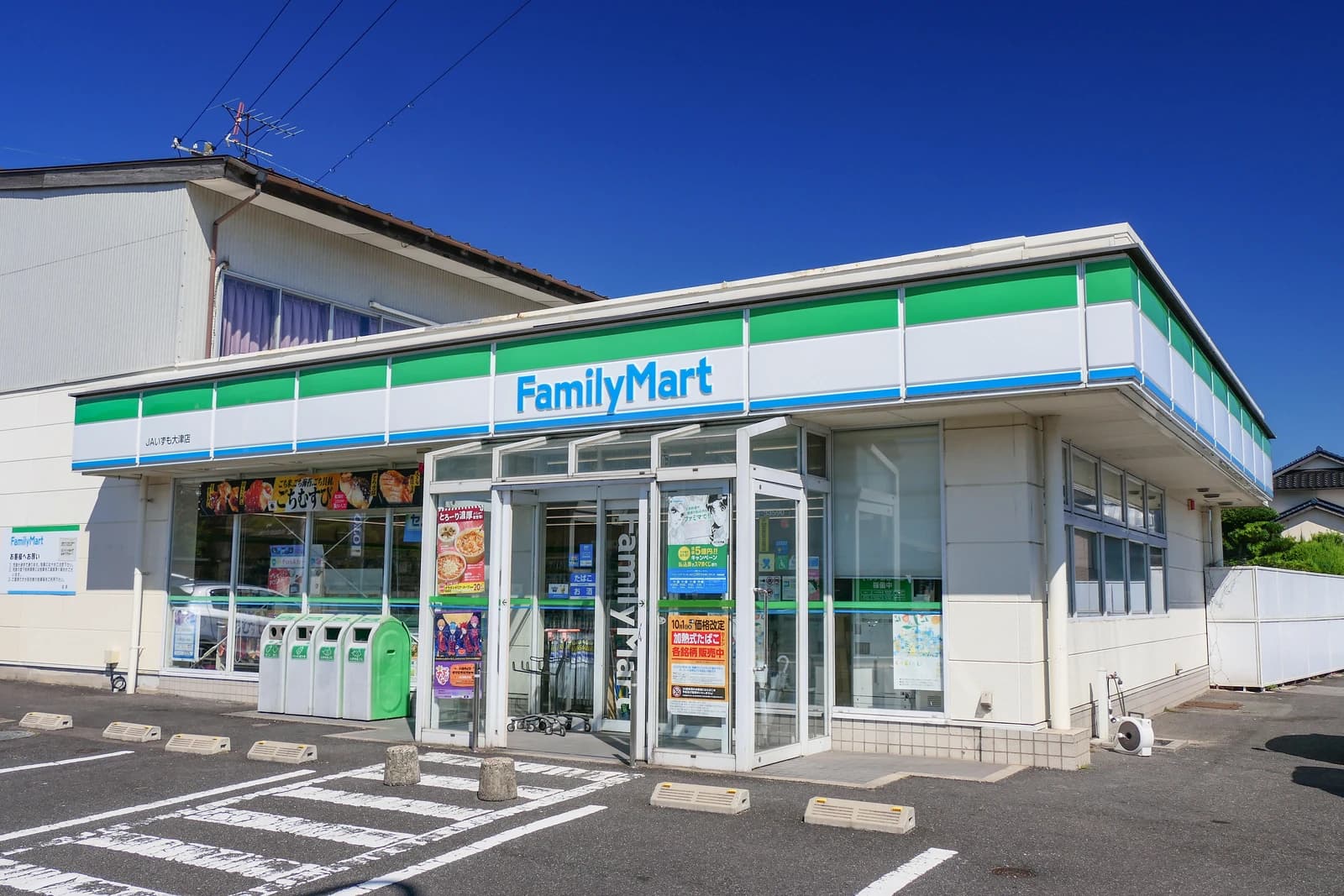 FamilyMart convenience store building exterior with blue and green signage, taken from the parking lot.