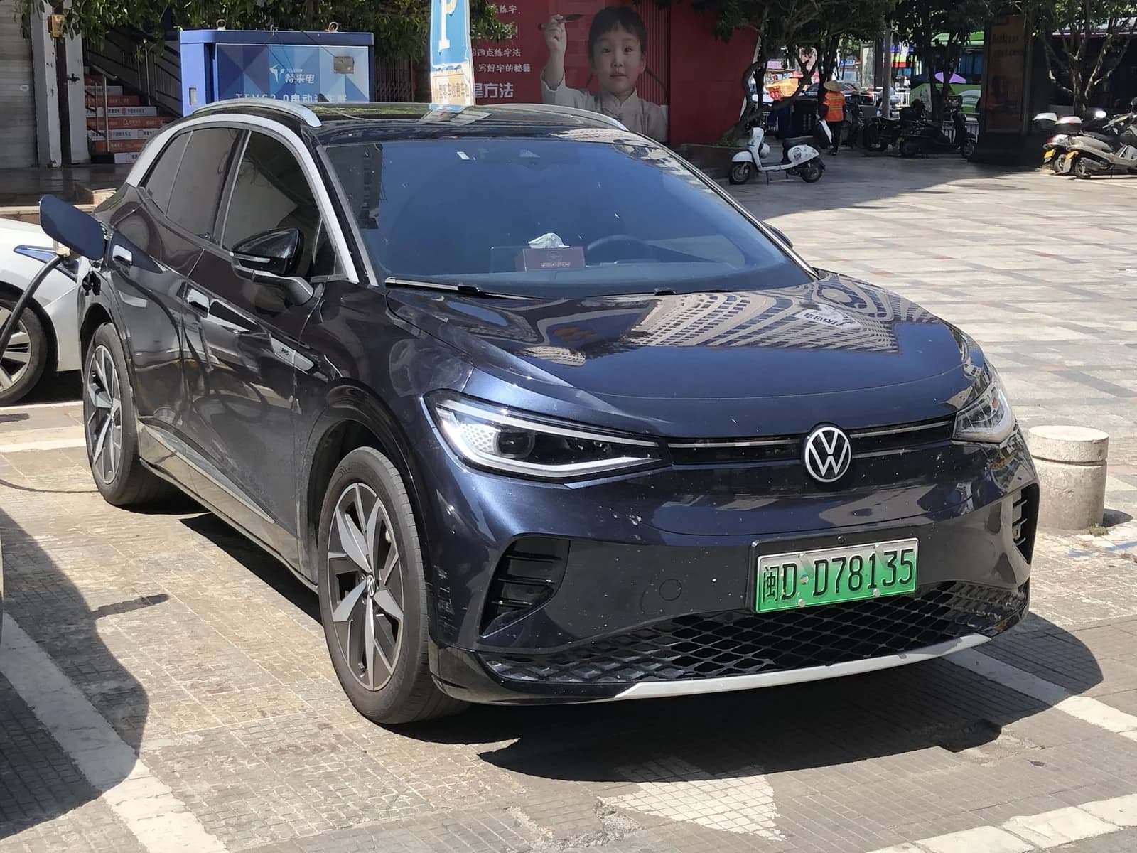 A dark blue Volkswagen ID.4 Crozz electric car parked and charging.