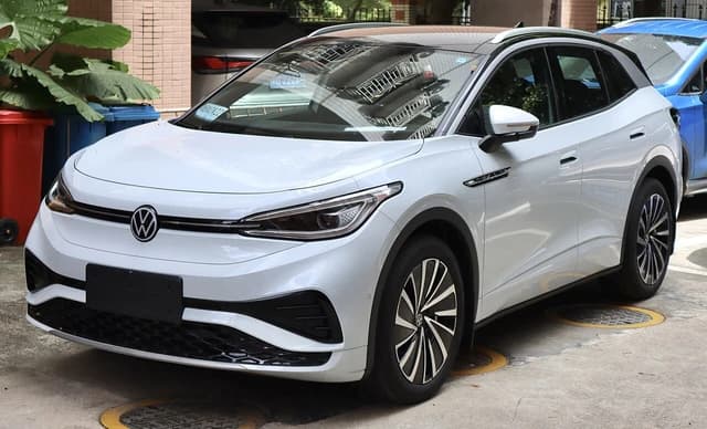 White 2023 SAIC-Volkswagen ID.4 X electric SUV parked on concrete with a building in the background.