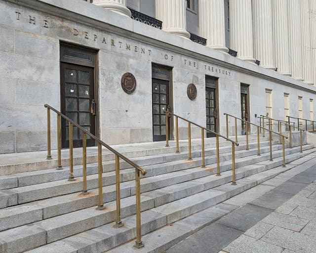 The Department of the Treasury building facade with stairs and bronze railings.