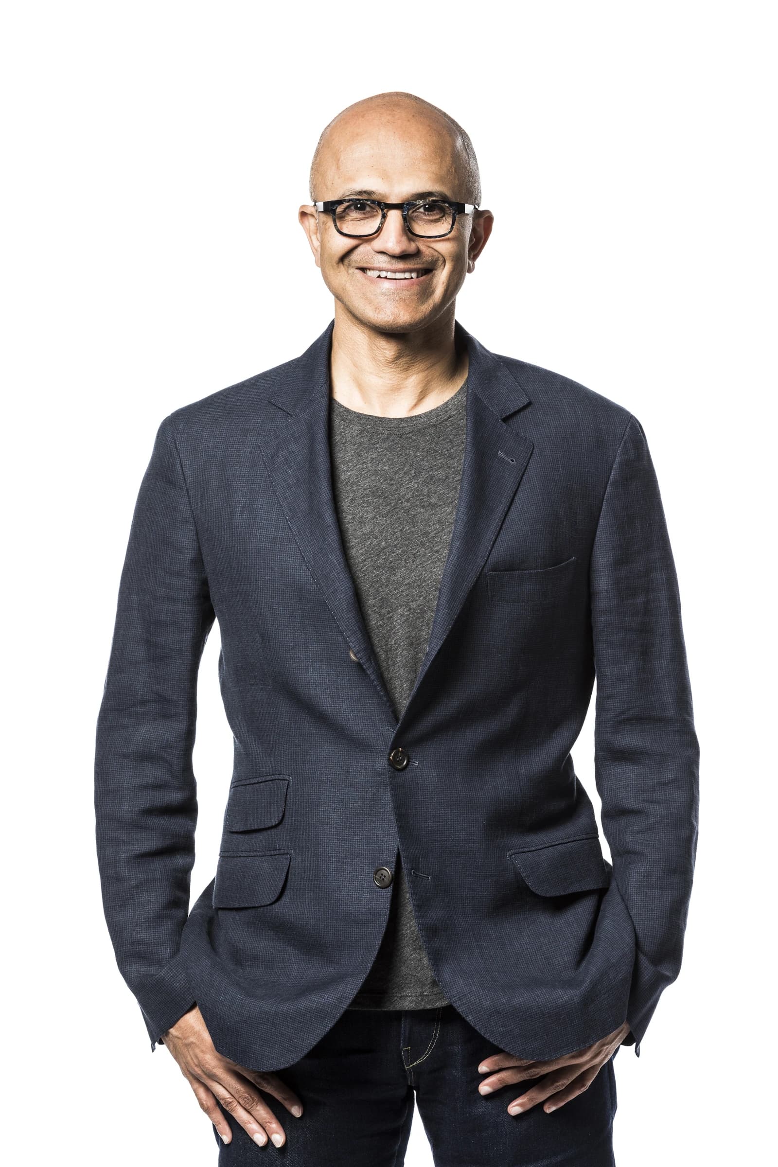 Satya Nadella, CEO of Microsoft, standing and smiling for a portrait.