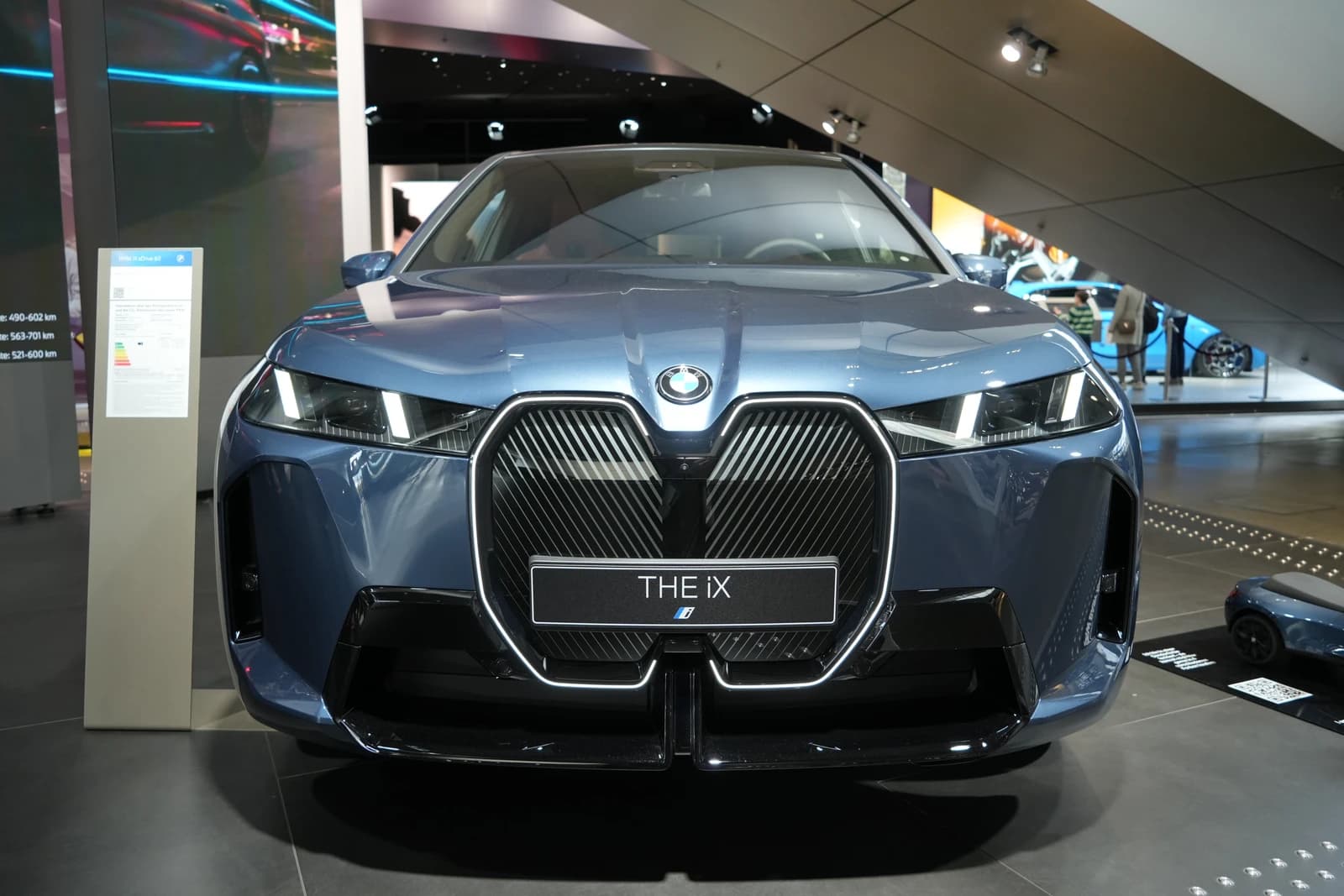 Front of a blue BMW iX xDrive 60 car on display.