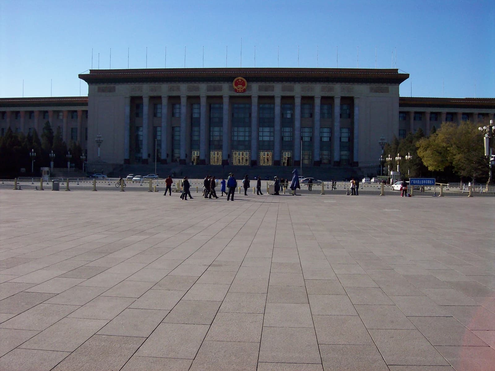 Great Hall of the People building with a large public square and pedestrians in front.
