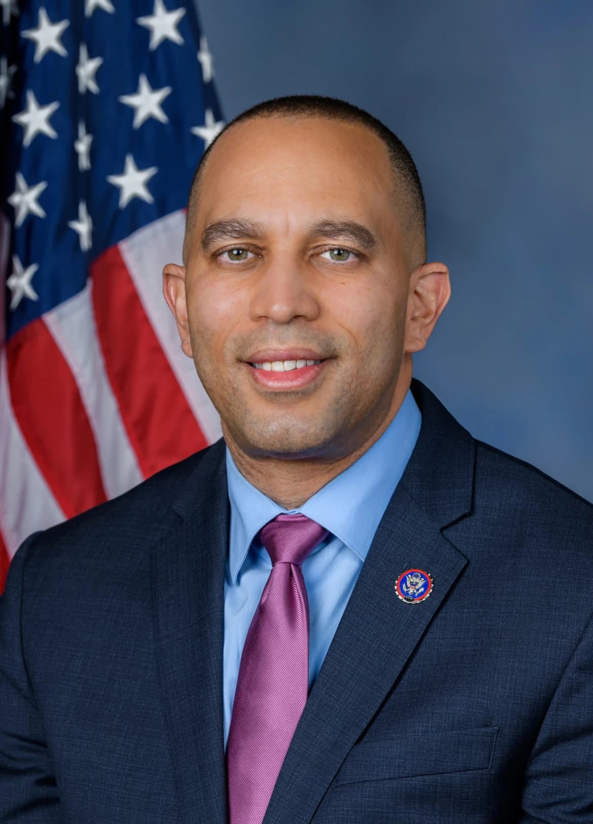 Hakeem Jeffries, U.S. Representative, smiling in an official portrait against an American flag.