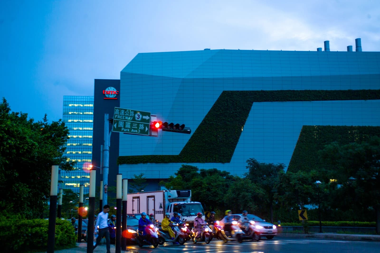 Evening view of a TSMC building in Hsinchu, Taiwan, with a busy street in front.