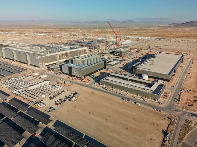 Aerial view of TSMC Fab 21 construction site with partially built structures.