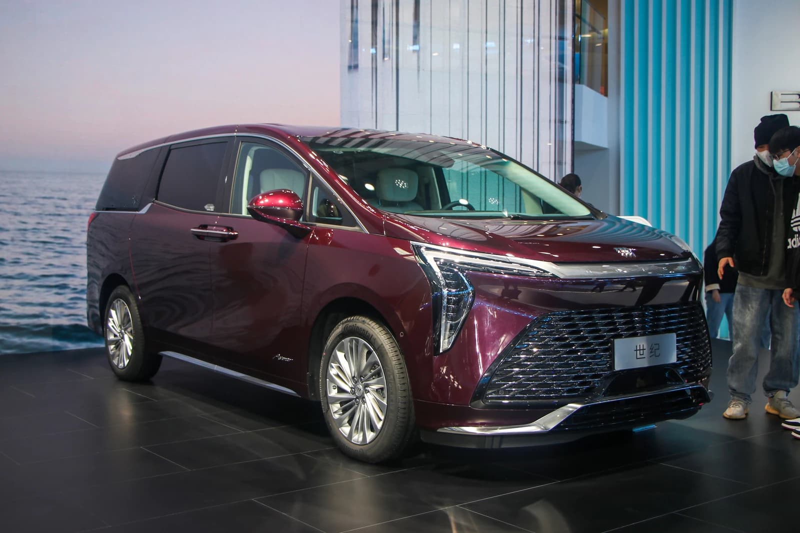 A maroon Buick GL8 Century minivan on display at an auto show.