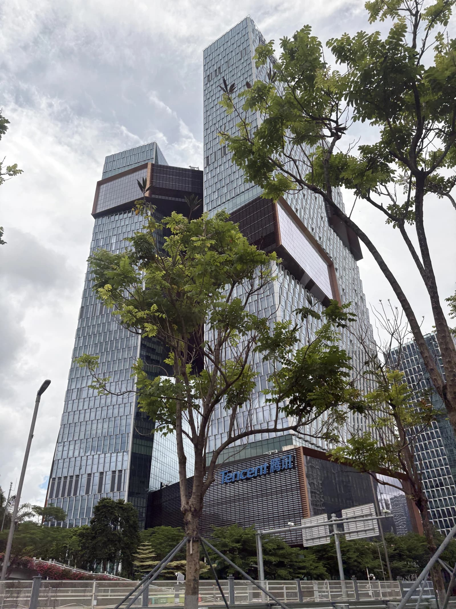 Tencent Seafront Towers, Tencent's headquarters, standing tall in Shenzhen against a cloudy sky.