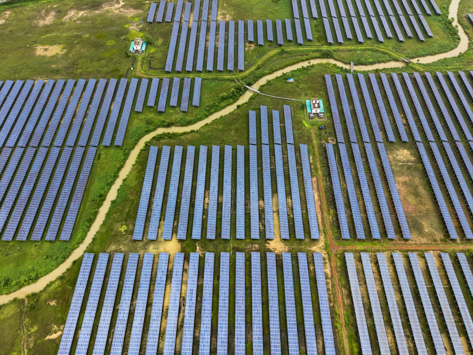Aerial view of rows of solar panels in a large-scale farm.