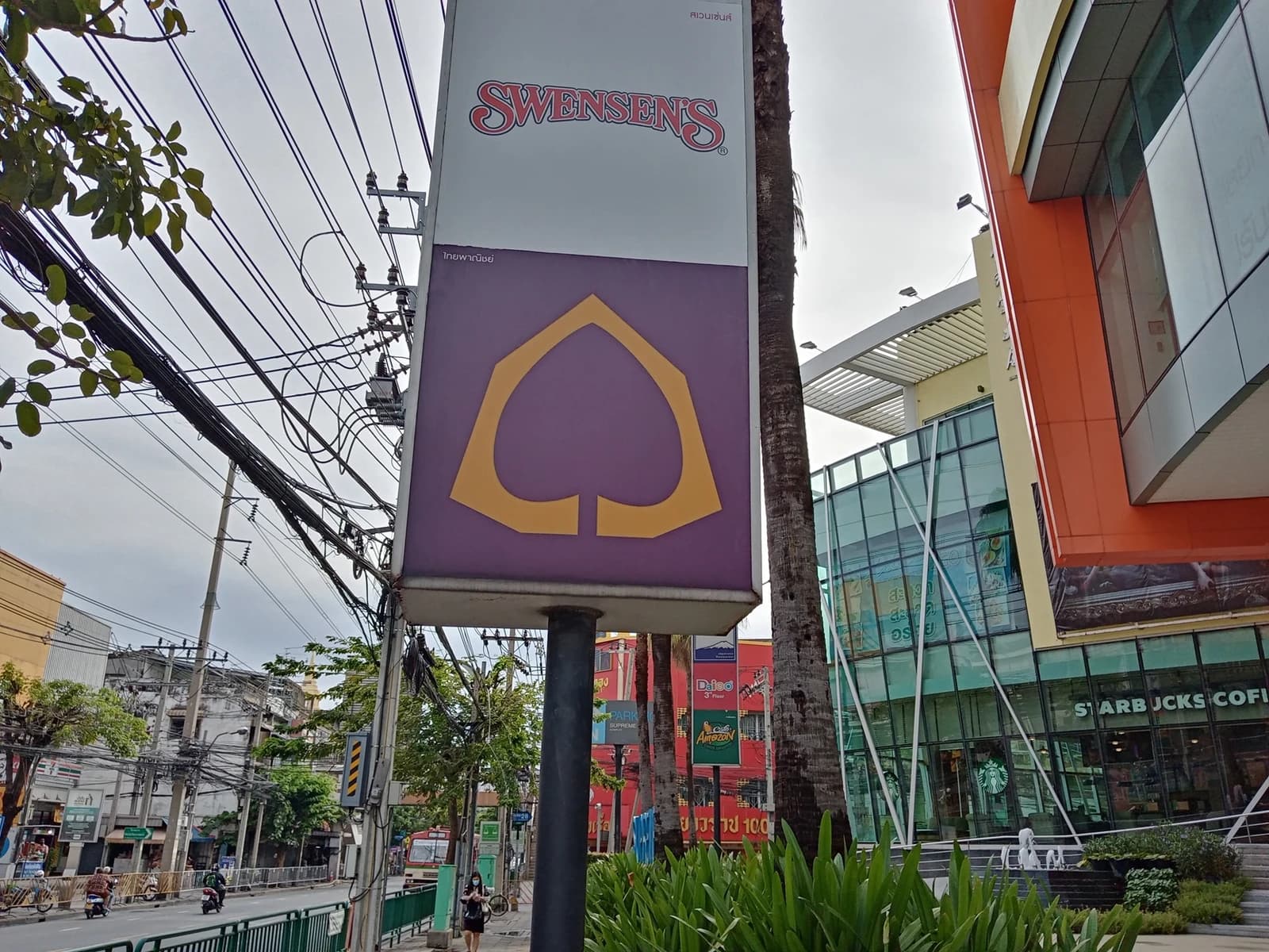 Siam Commercial Bank logo and Swensen's sign on a street in Thailand.