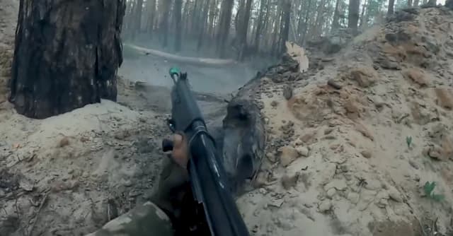 Fighter of the 2nd Battalion International Legion aiming a rifle in a trench.