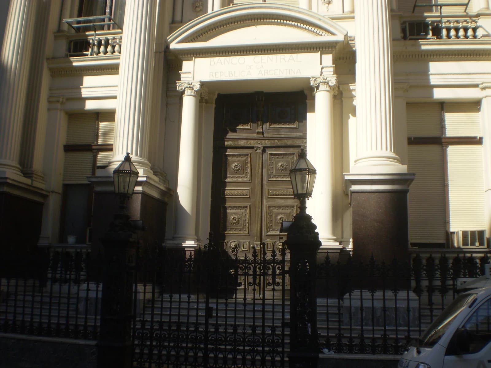 Central Bank of the Argentine Republic building, exterior, ornate door, columns, iron fence.