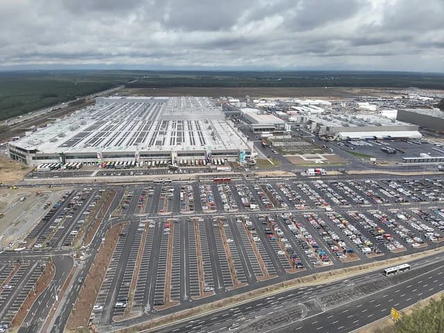 Aerial view of Tesla Gigafactory 4 with surrounding parking lots and roads.