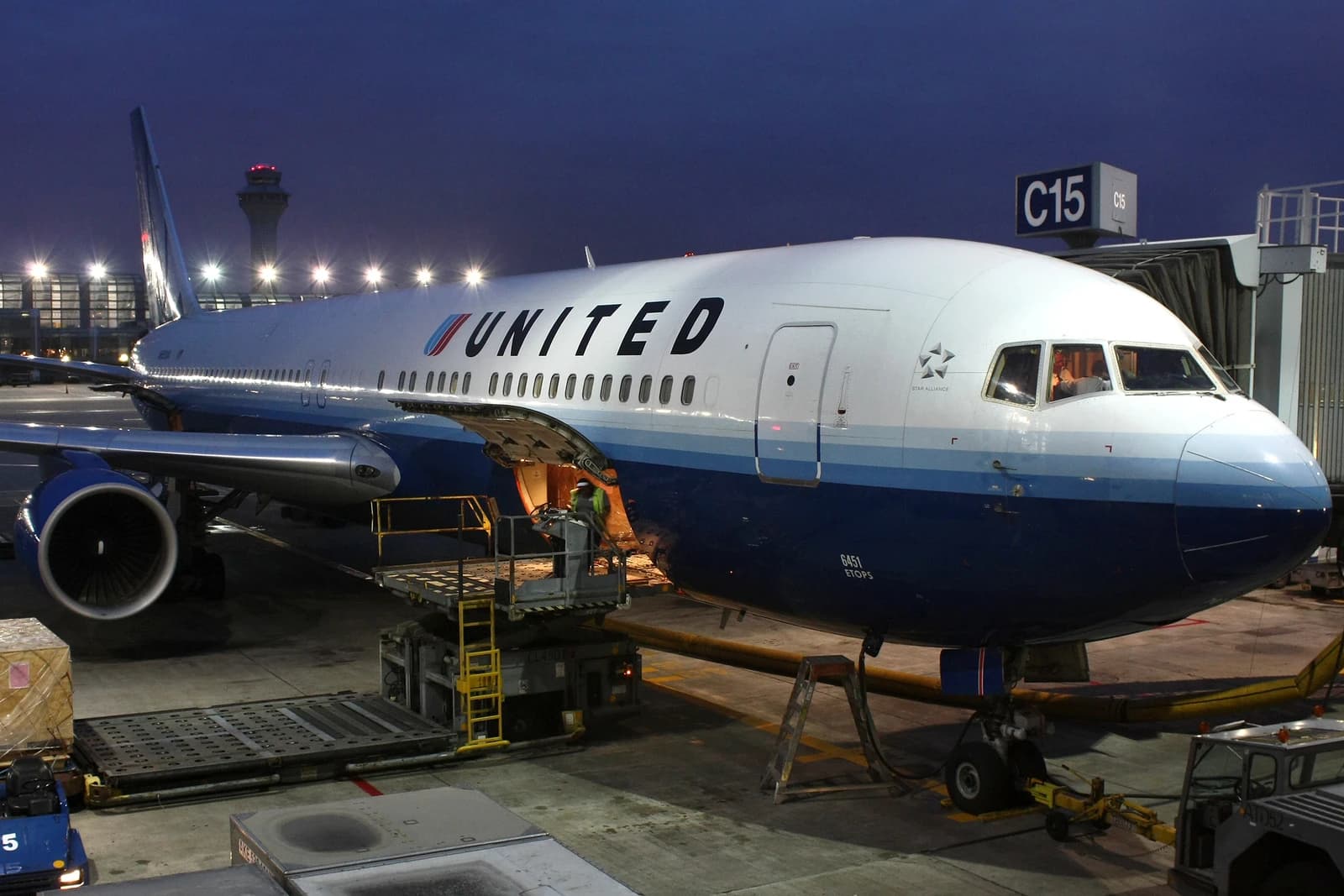 United Airlines Boeing 767 aircraft N651UA parked at a gate at dusk.