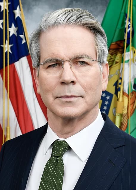 Scott Bessent, Treasury Secretary, in an official portrait against flags.
