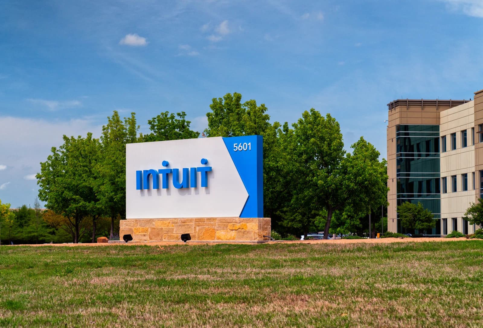 Exterior view of the Intuit company sign with green grass and a corporate building.