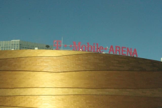 T-Mobile Arena sign with large red letters on top of a golden building.