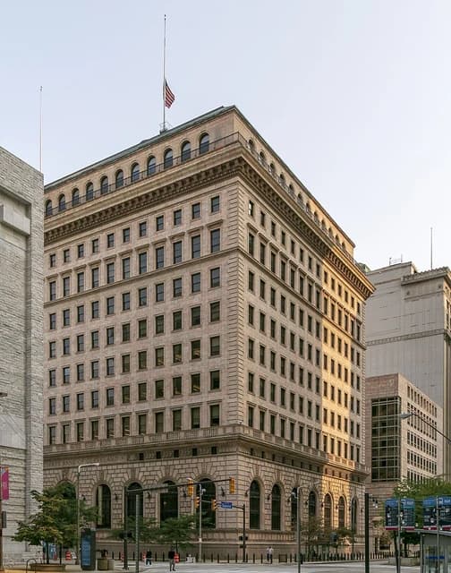Federal Reserve Bank building in Cleveland, Ohio, with an American flag flying at half-staff.