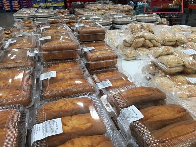 Many packaged cakes, cookies, bread, and other baked goods on a store display.