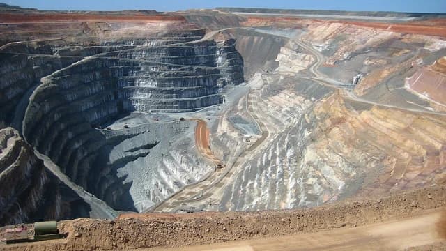 Sunrise Dam Gold Mine open pit with terraced walls and mining vehicles.
