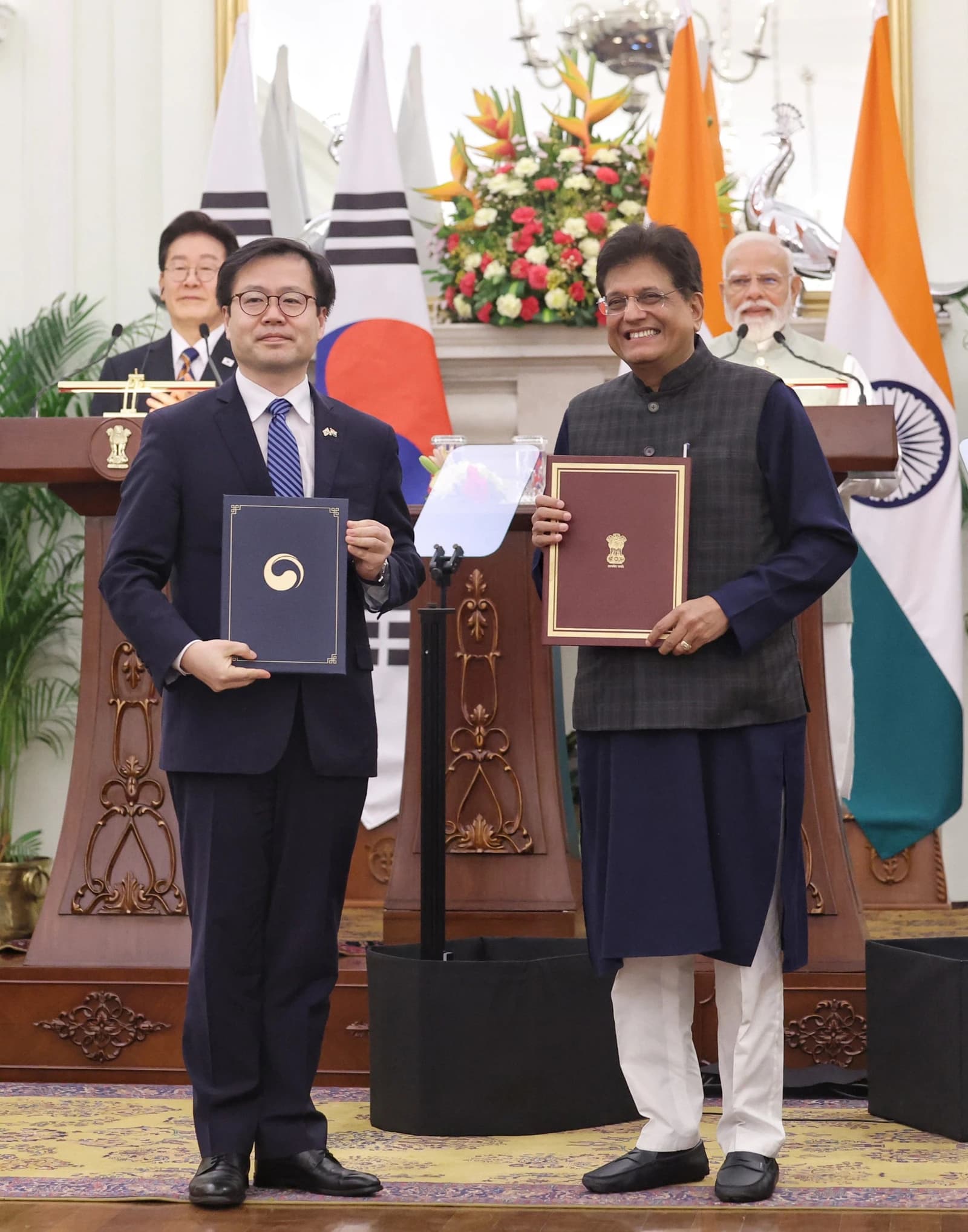 Piyush Goyal, Minister of Commerce and Industry, and Yeo Han-koo exchanging documents at a ceremony.