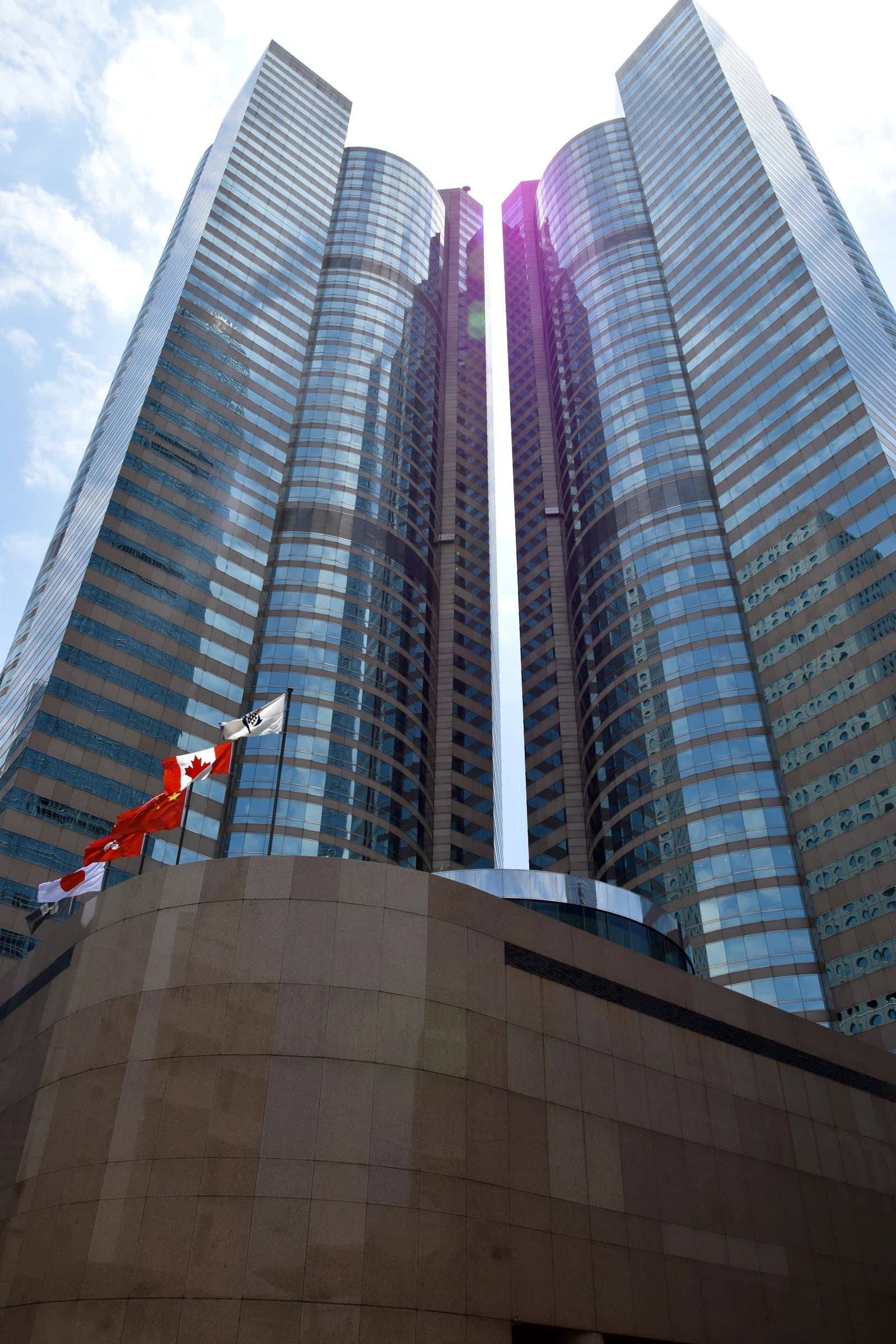 Exchange Square building in Hong Kong, with flags of Canada, Hong Kong, and Japan.