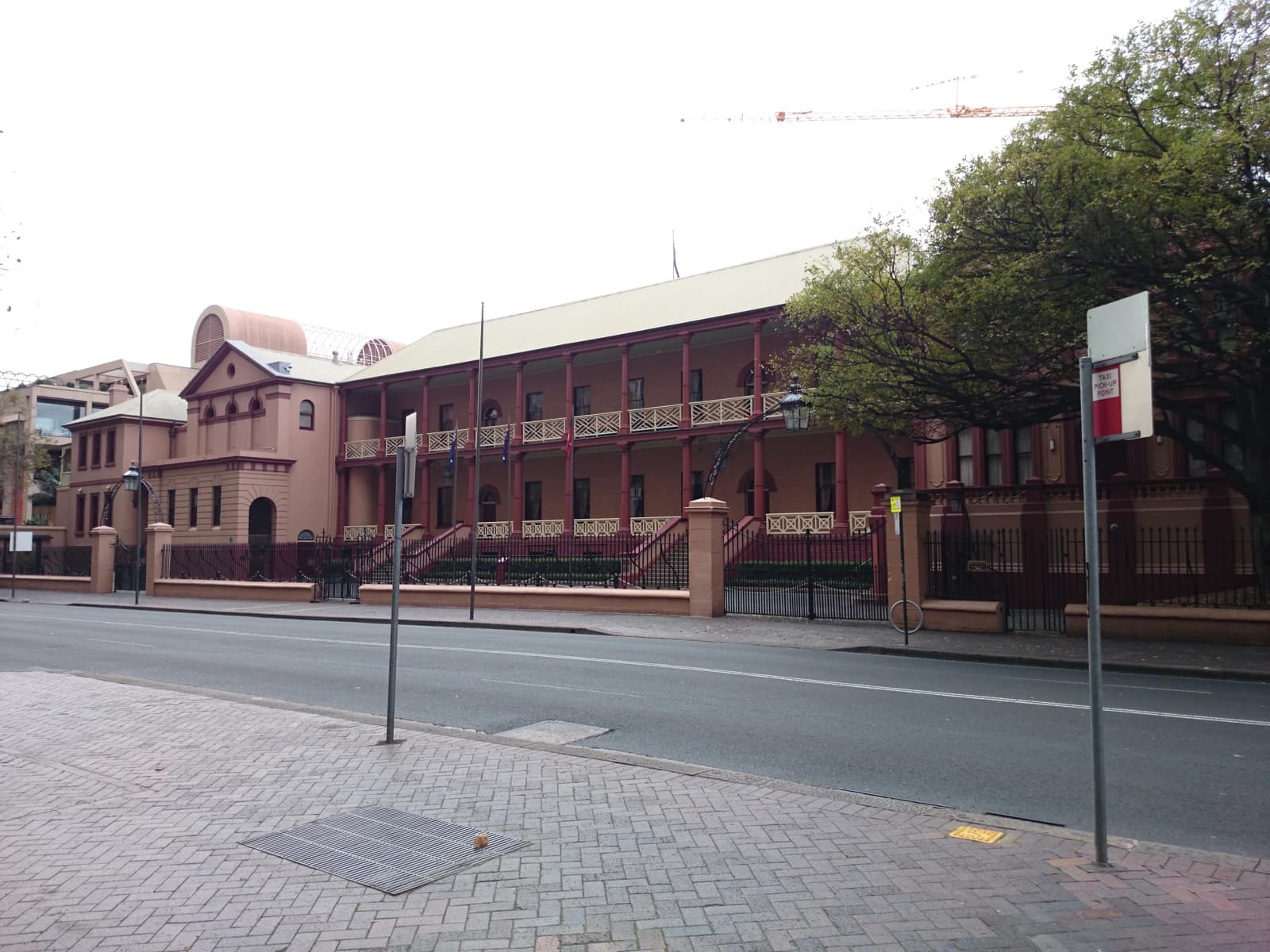 New South Wales Parliament House, a historic building with balconies, gates, and trees, on Macquarie Street.