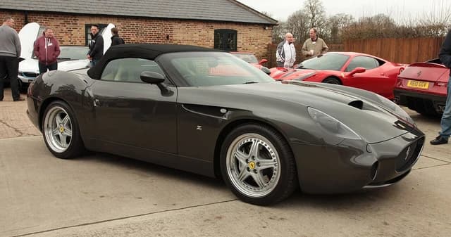 Gray Ferrari 550 GTZ Barchetta parked outdoors, surrounded by other cars and observers.