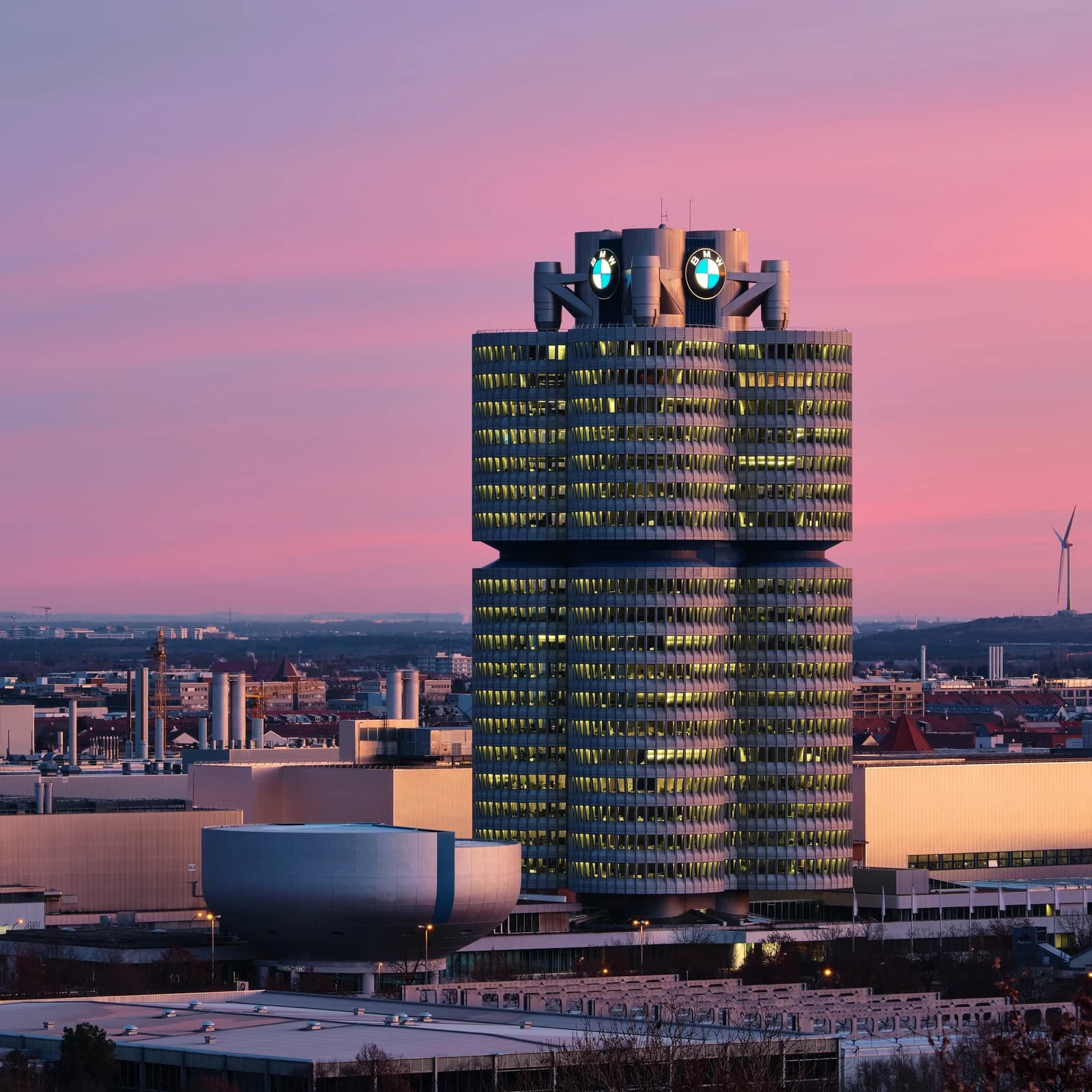 BMW Group Headquarters in Munich, Germany, with a pink sky at sunset.