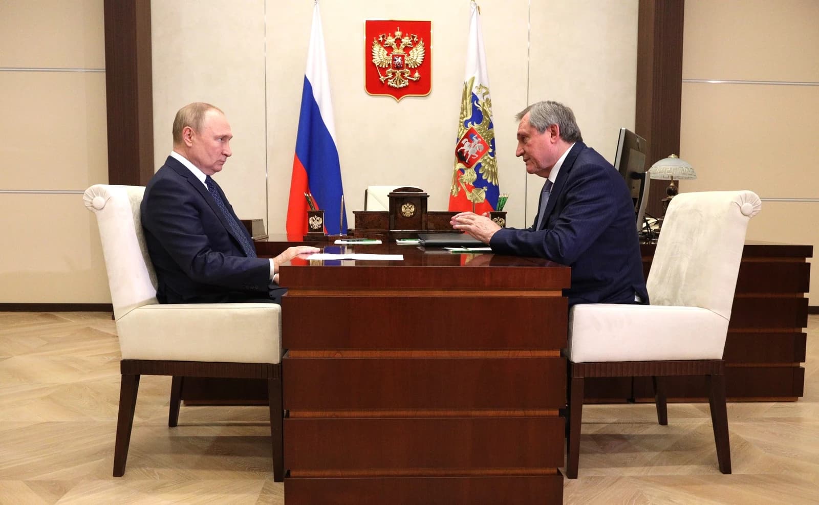 Vladimir Putin and Andrey Shulginov sit at a desk during a meeting.