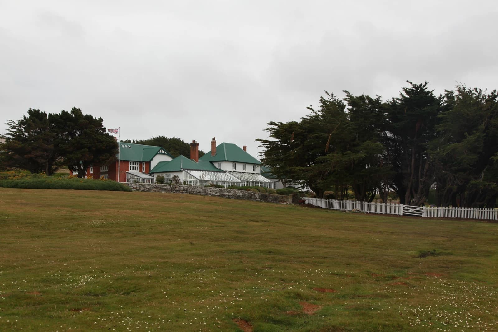 Government House, the official residence of the Governor of the Falkland Islands, seen from a grassy field.