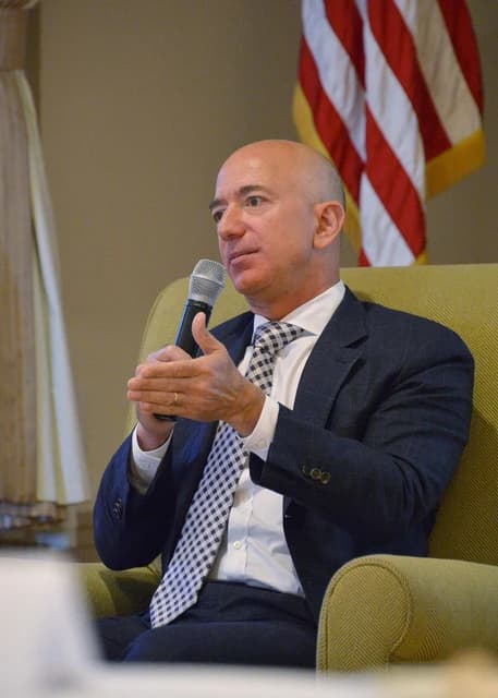 Jeff Bezos, founder of Amazon, speaking into a microphone at an event.