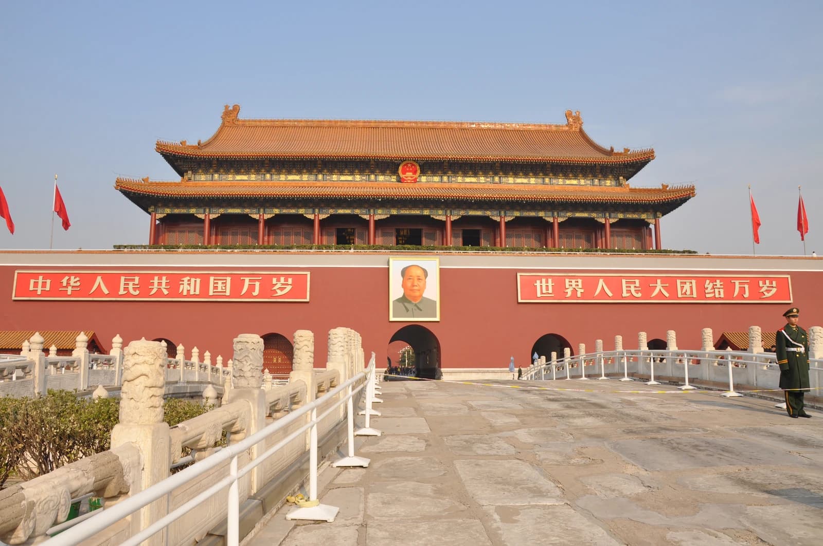 Tiananmen Gate, displaying a portrait of Mao Zedong, with a soldier standing guard.