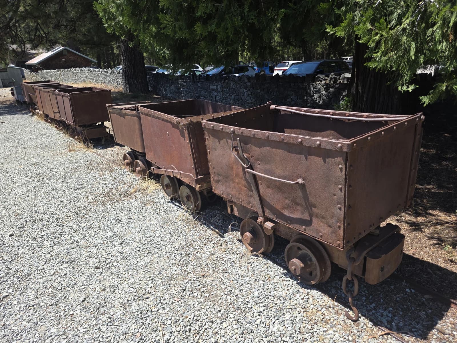 Rusty mining carts standing on tracks at the Empire Mine State Historic Park.