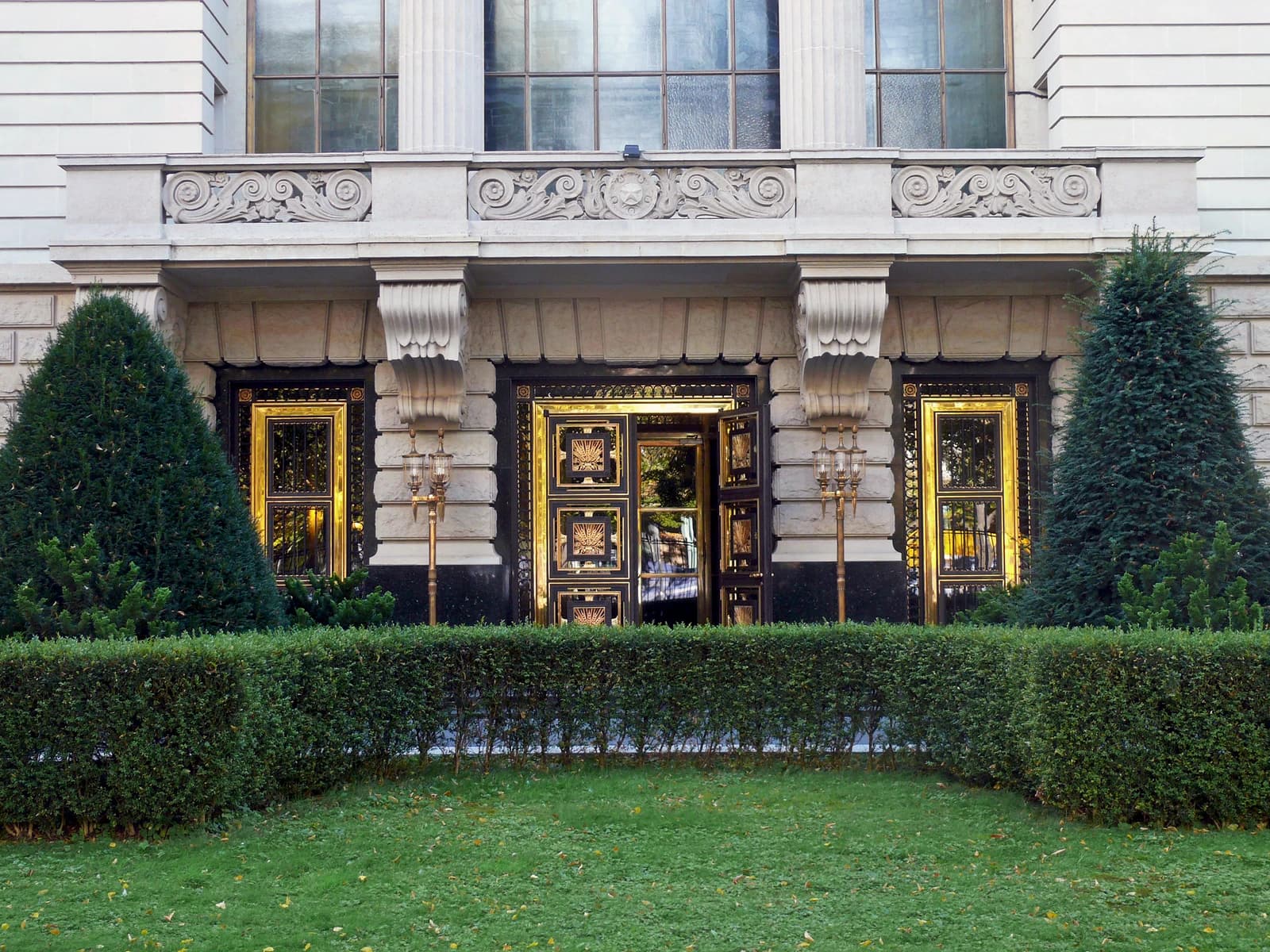 Exterior of the Russian embassy building in Berlin, with ornate golden doors and green landscaping.