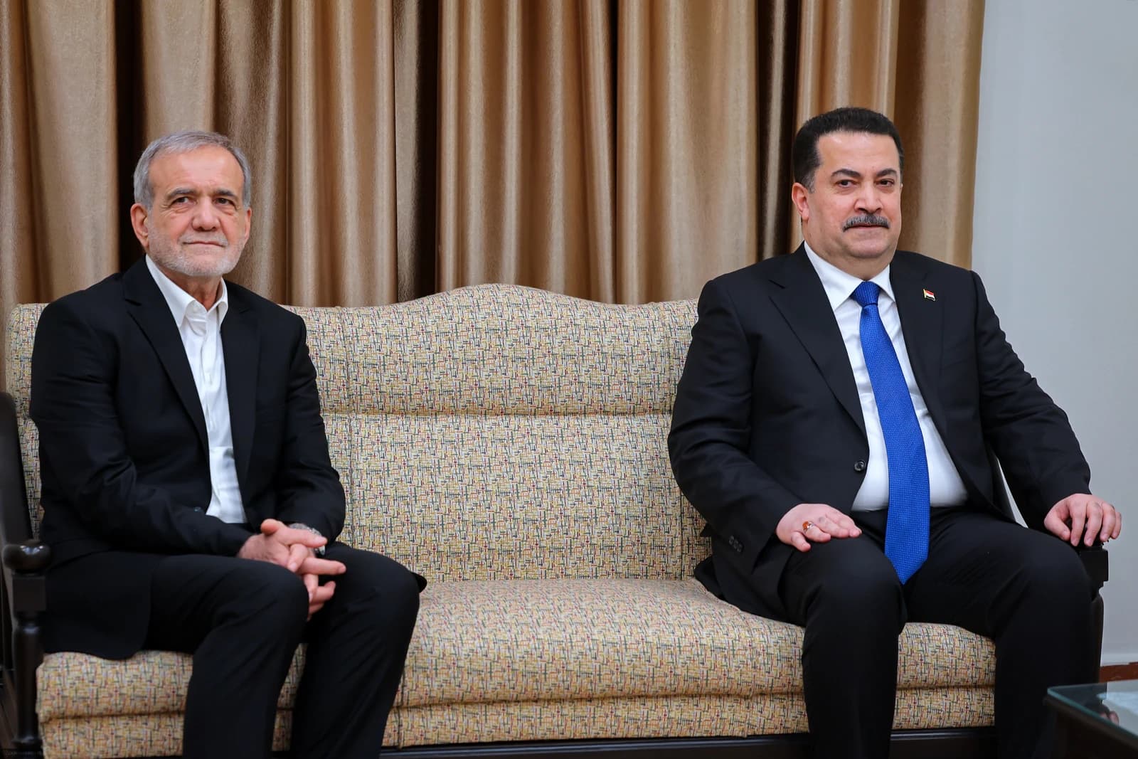 Masoud Pezeshkian and Mohammed Shia' Al Sudani sit on a sofa indoors.