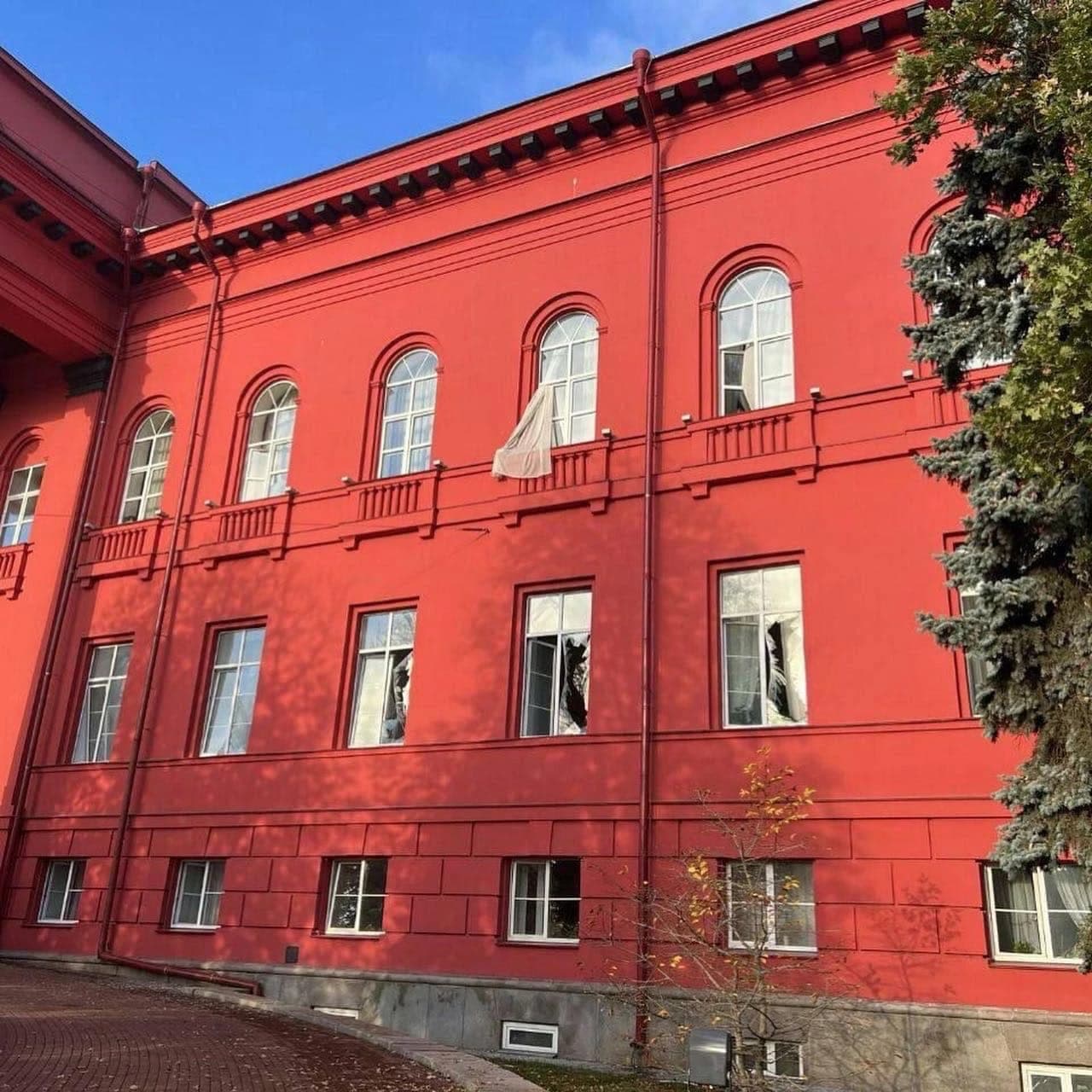 Red building of the National University of Food Technologies with broken windows in Kyiv.
