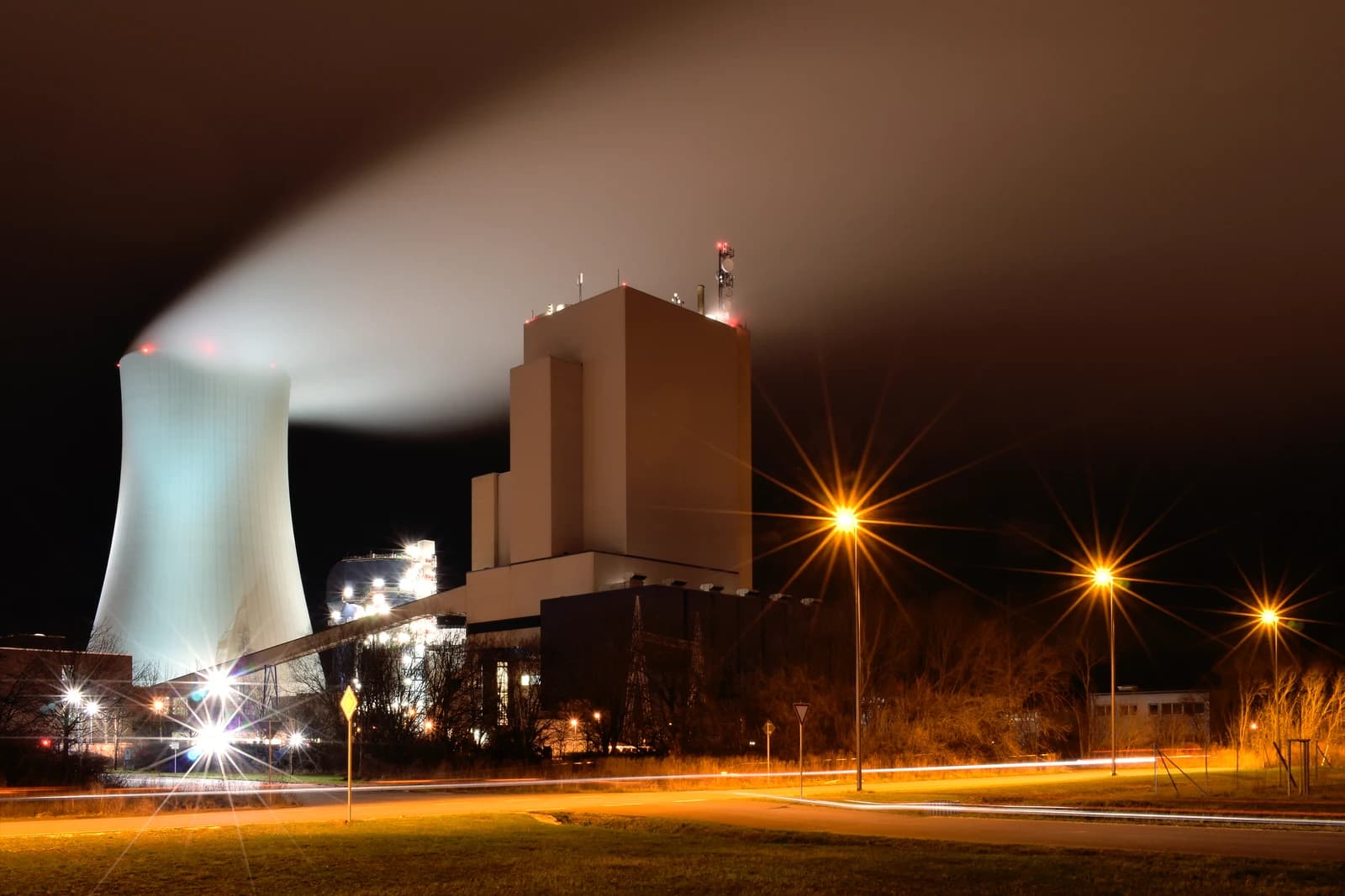 Rostock Power Station at night with a large cooling tower and main building illuminated.