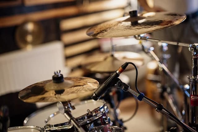 Drum set and cymbals are ready for practice in a music studio.