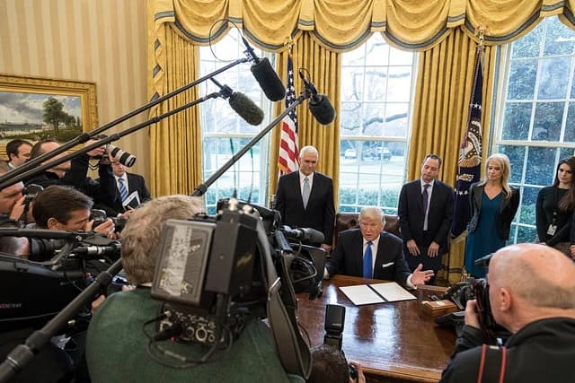 Donald Trump, President of the United States, speaks at his desk in the Oval Office.