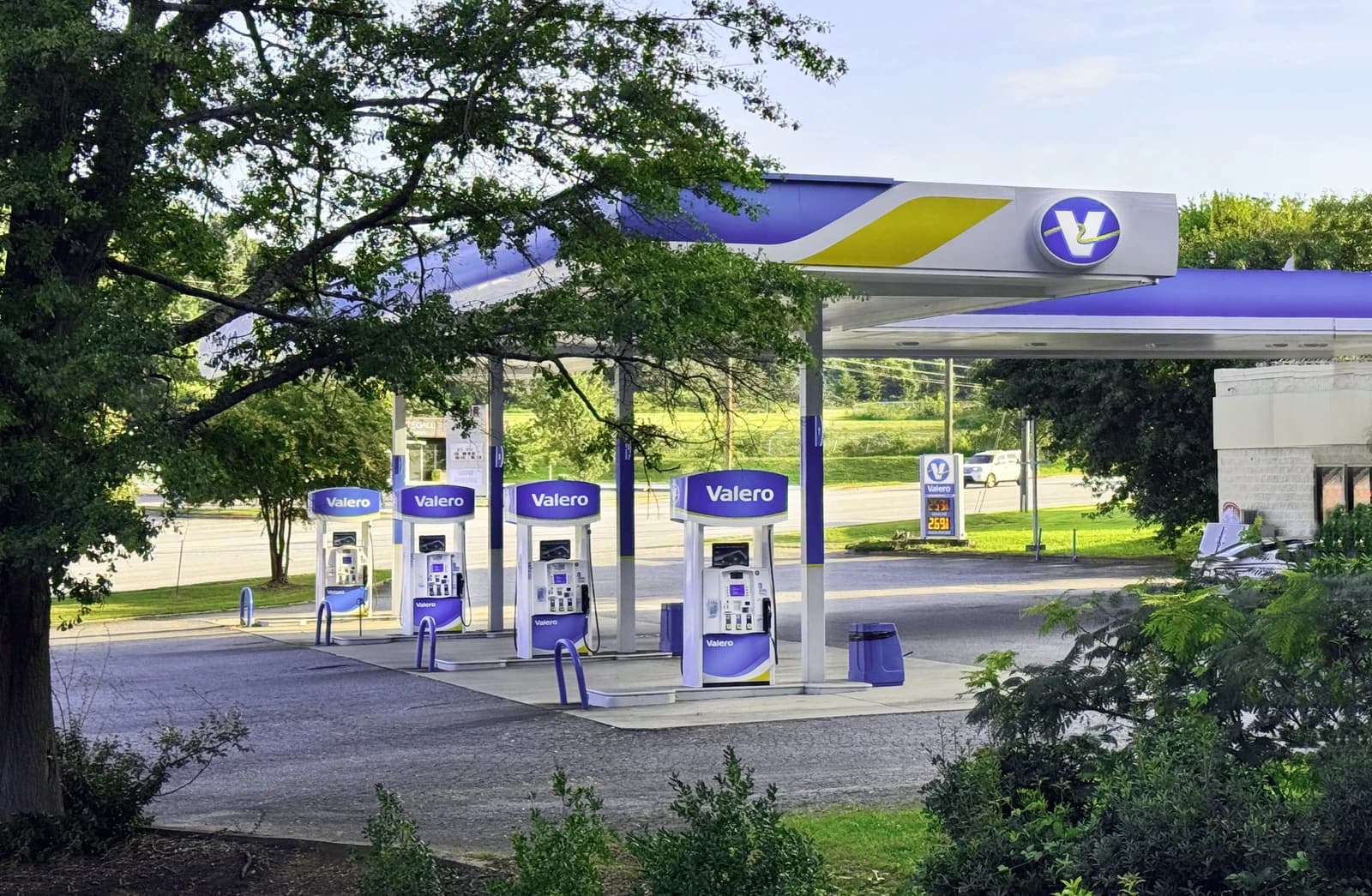 Fuel pumps at a Valero gas station in Greenville, South Carolina, under a clear sky.