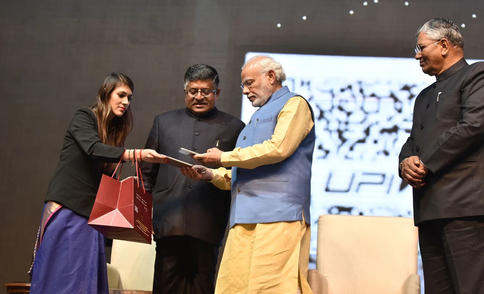 Indian Prime Minister Narendra Modi reviewing a tablet during an event.