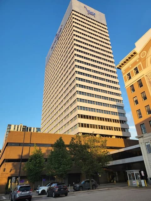 Kroger headquarters building, a tall corporate structure, under a clear blue sky.