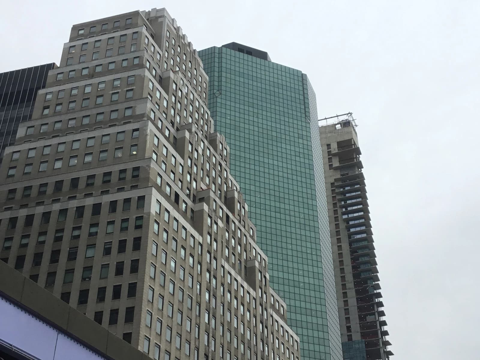 Skyscrapers loom under a cloudy sky in Manhattan's Financial District.