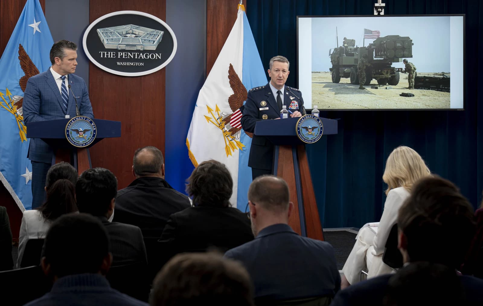 Secretary of Defense Pete Hegseth standing at a podium at the Pentagon press briefing.