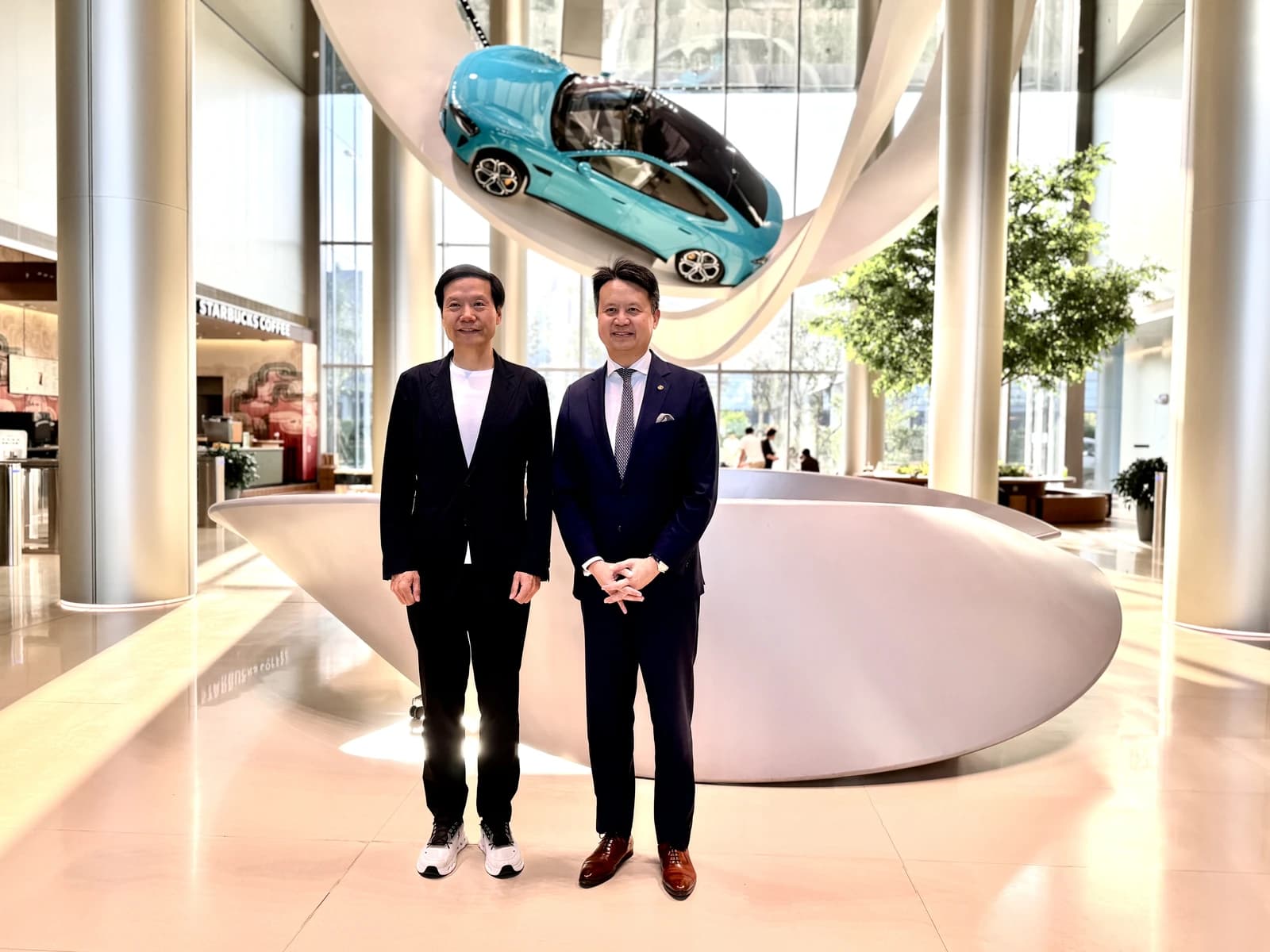 Daren Tang and Lei Jun standing inside Xiaomi EV plant.
