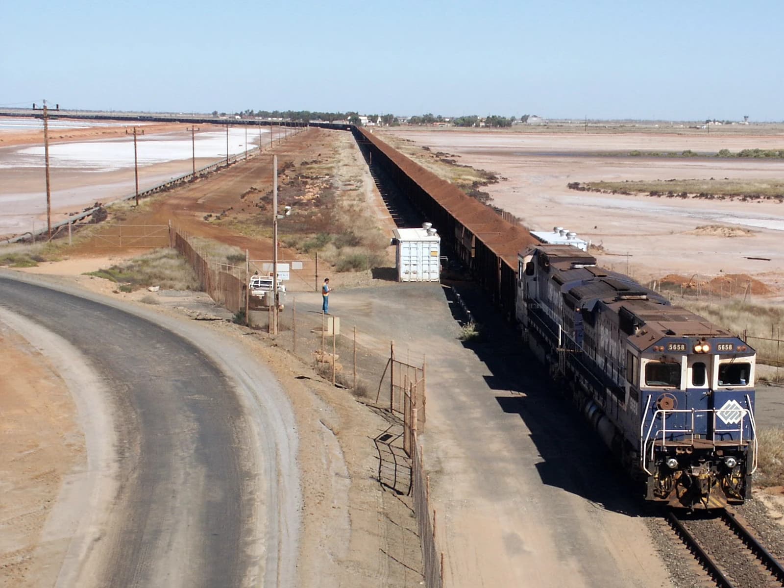 Locomotive 5658 pulling a long train of iron ore freight cars in Port Hedland.